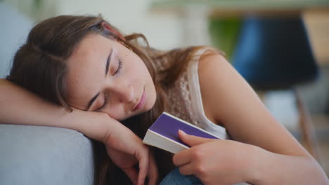 mujer durmiendo mientras lee un libro aburrido