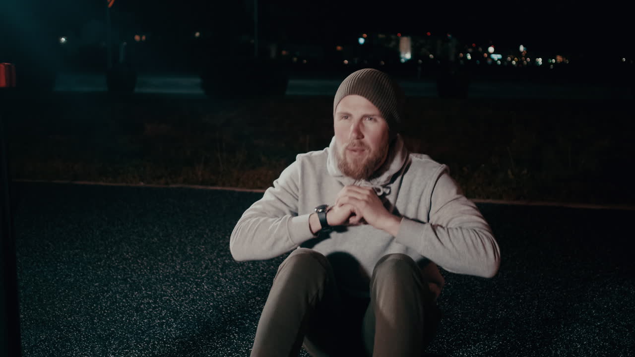 Man Doing Sit-ups Outdoors at Night