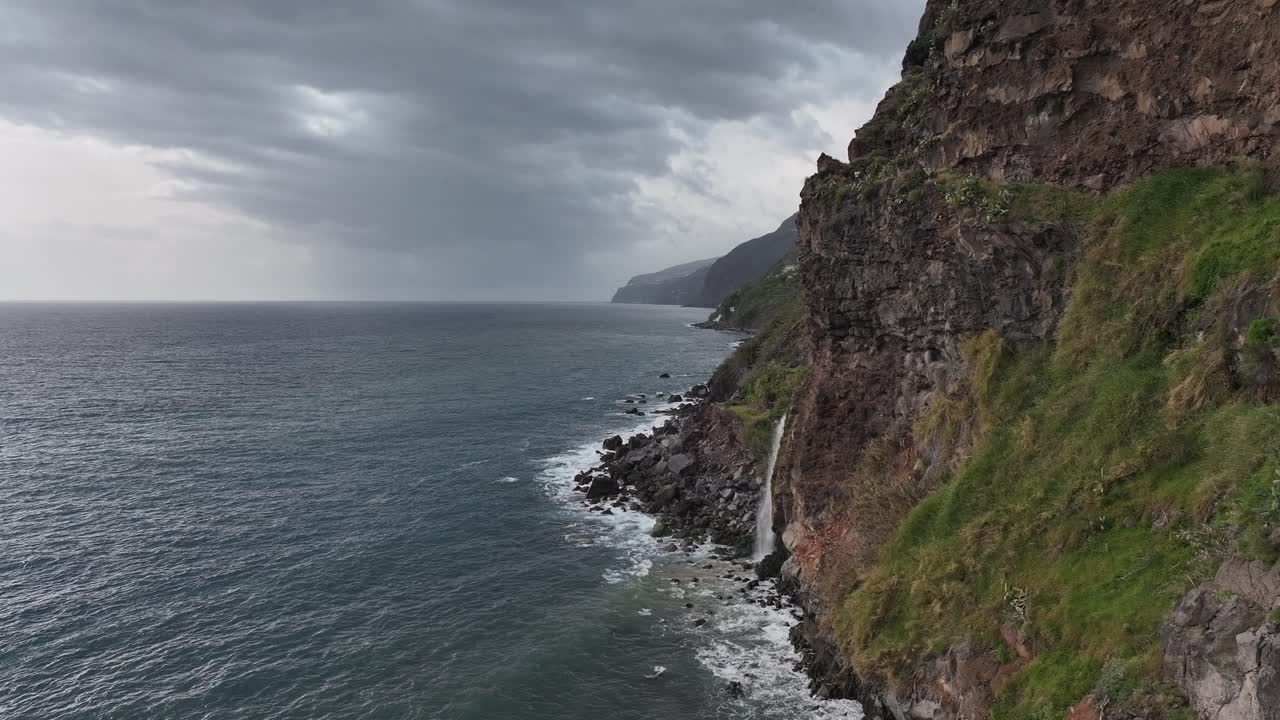Marvel at the breathtaking sight of a waterfall flowing directly into the ocean, captured from above in Madeira. This stunning aerial footage highlights the island’s unique natural wonders