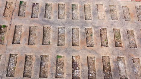 abstract pattern of rectangular concrete grid with dirt and stones