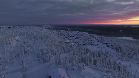 un avión no tripulado gira en torno a una aldea en la cima de iso-syote, puesta de sol en finlandia