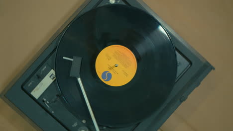 toma cinematográfica cenital de un disco girando sobre un tocadiscos