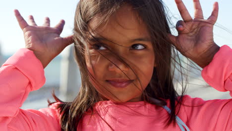 océano, la infancia y el rostro de la niña con las manos