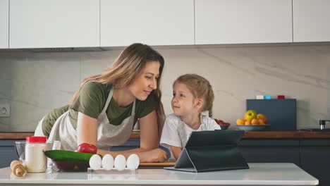 Niña-Y-Madre-Felices-De-Encontrar-Una-Nueva-Receta-Con-Tableta