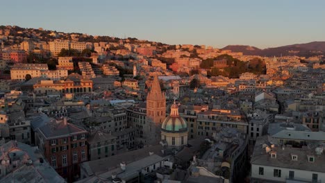 Hora-Dorada-Sobre-El-Centro-Histórico-De-Génova-Con-Una-Luz-Cálida-Que-Baña-Los-Edificios,-Vista-Aérea