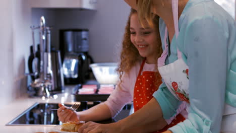 Mother-serving-tart-in-kitchen