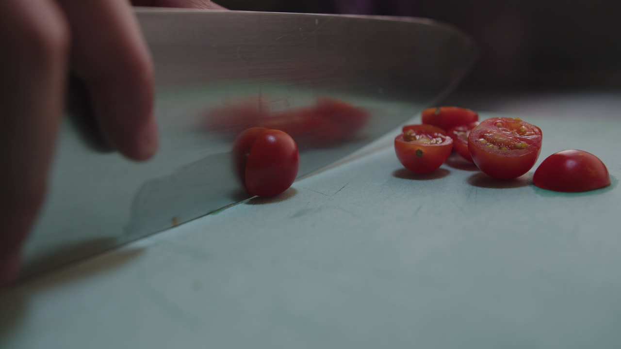 Close-up of Hands Cutting Cherry Tomatoes with a Knife