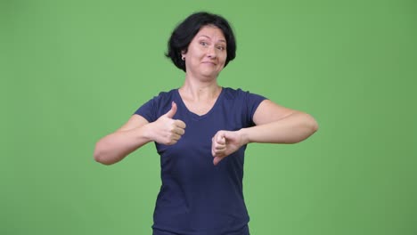 beautiful woman with short hair choosing between thumbs up and thumbs down