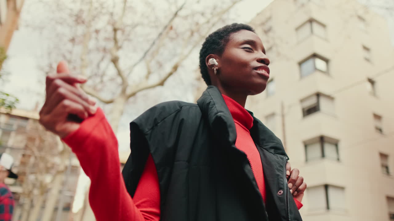 Happy Young Black Woman Dancing to Music in the City