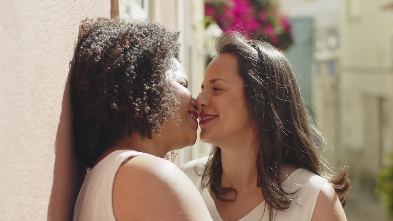 noivas lésbicas felizes se beijando ao ar livre após a cerimônia de  casamento