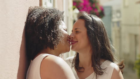 happy lesbian brides kissing outdoors after wedding ceremony