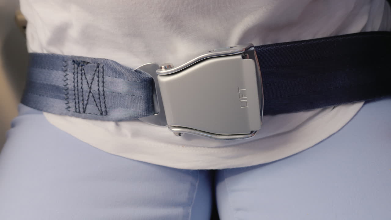 한 여성이 비행기에서 안전 벨트를 매고 나중에 항공 운송의 안전을 풀다