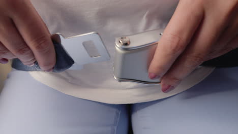 a woman fastens the seat belt on the plane and unfastens it later safety of air transportation