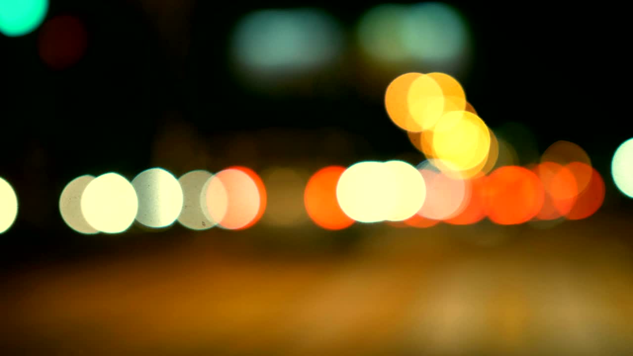 conducir un coche a través de la carretera de la noche, la autopista. luces desenfocadas calle de los ángeles resumen. ciudad fondo borroso. movimientos círculos bokeh de tráfico nocturno.