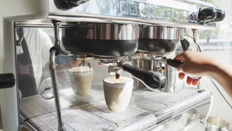 mid section of african american male barista making coffe at cafe