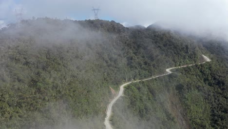 gravel road cut high into steep cloudy jungle mountain side in bolivia