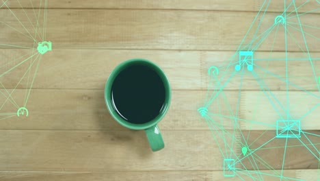 Animation-of-connected-icons-globes-over-overhead-view-of-coffee-cup-on-wooden-table