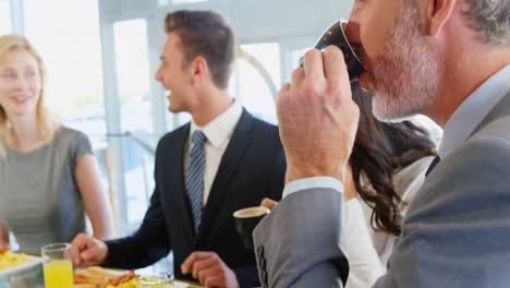 Hombres-Y-Mujeres-De-Negocios-Interactuando-Entre-Sí-Mientras-Desayunan.