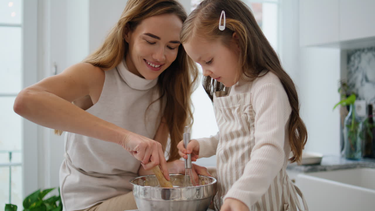 Mom daughter whisking dough indoors closeup. Mother kid mixing flour together