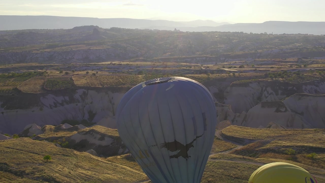 Mongolfiera sorvola il paesaggio della Cappadocia al tramonto.