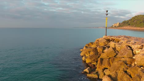 meteorological instrument on rocky coast of roc de sant gaieta at golden hour