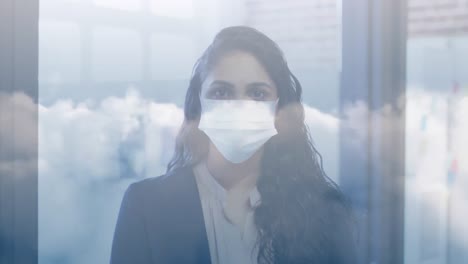 Nubes-En-El-Cielo-Azul-Contra-El-Retrato-De-Una-Mujer-India-Que-Usa-Máscara-Facial-En-La-Oficina