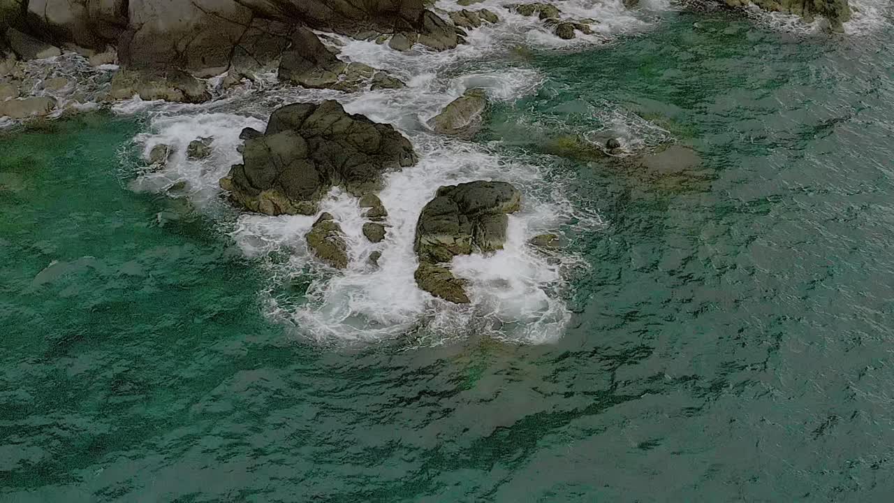 Prospettiva aerea con inclinazione verso il basso di acque turchesi e rocce costiere nella baia di Looc, Filippine