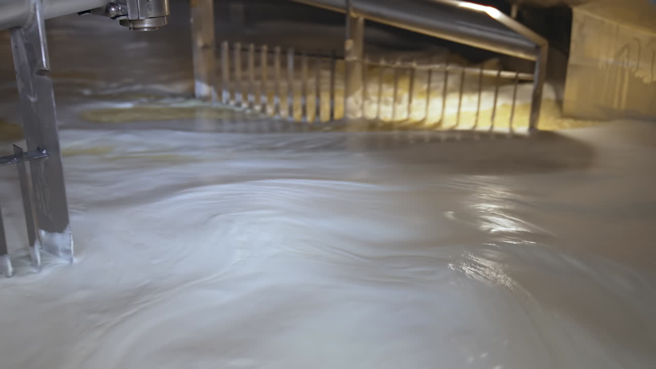 Process of making butter on a milk farm. Industrial equipment mixing dairy liquid for butter production. Close-up.