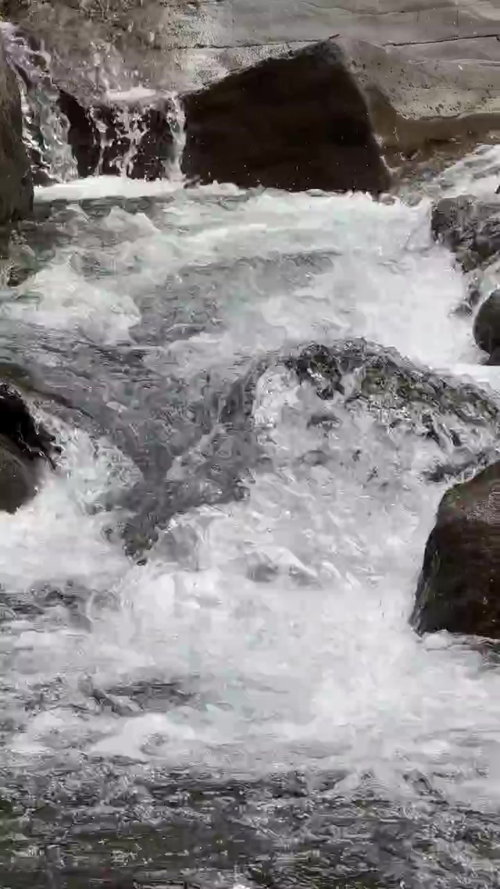 Ruscello di montagna limpido che scorre su rocce levigate