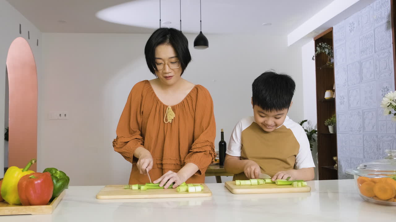 엄마와 소년이 부추를 자르고 있습니다.