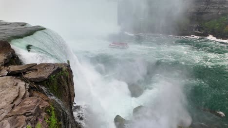 aerial view of niagara falls with tourist boat sailing close to the waterfall through rising mist. aerial view of niagara falls with tourist boat sailing close to the waterfall through rising mist