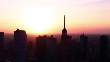 dark warsaw cityscape in front of bright orange sunset