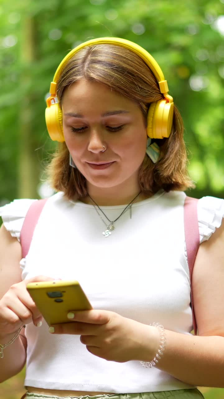 Woman listening to music with headphones in a park