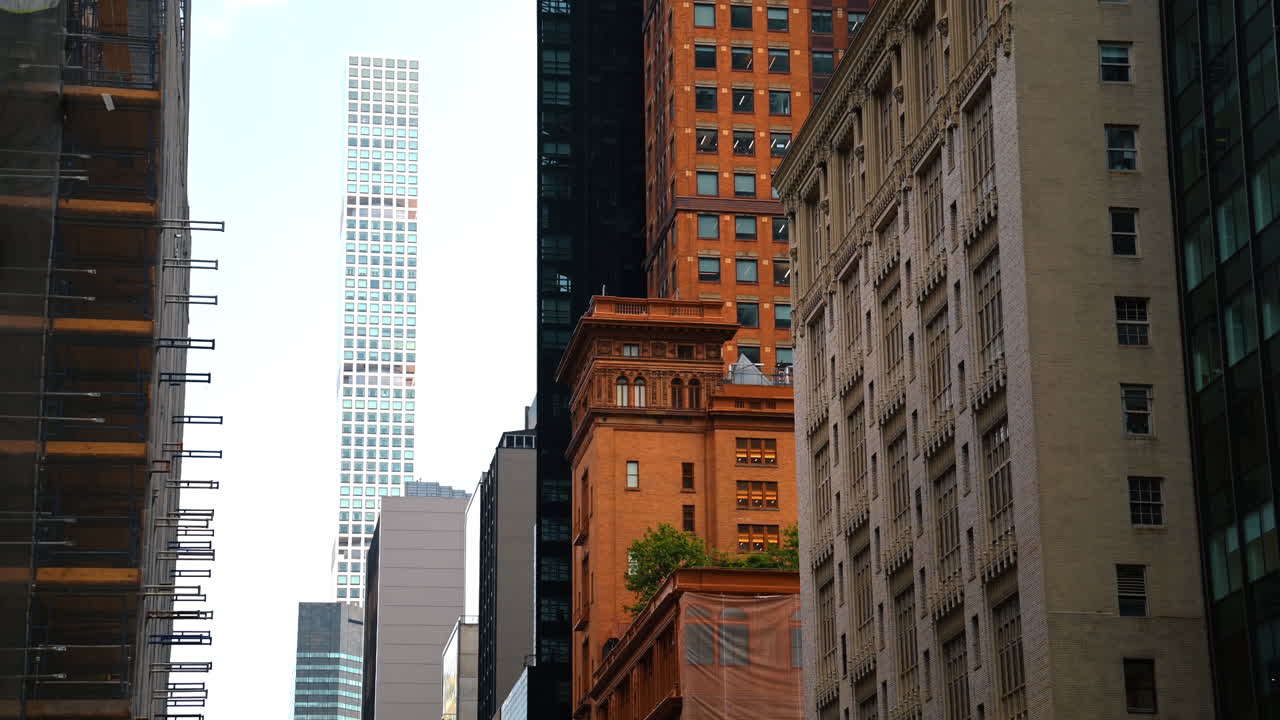 Edifícios históricos e modernos em Midtown Manhattan. Vista de edifícios históricos vermelhos e bege misturados com arranha-céus modernos em Midtown Manhattan