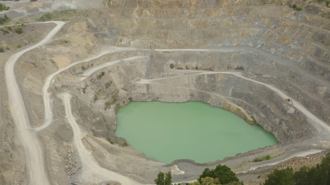 Slow drone fly over quarry showing interior access roads and machinery