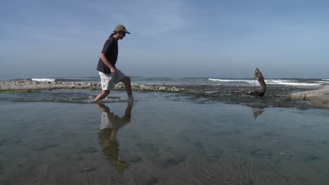 Panorámica-Del-Hombre-Caminando-Por-El-Agua-En-El-Estuario-Del-Río-Ventura-En-Surfers-Point-En-Ventura-California