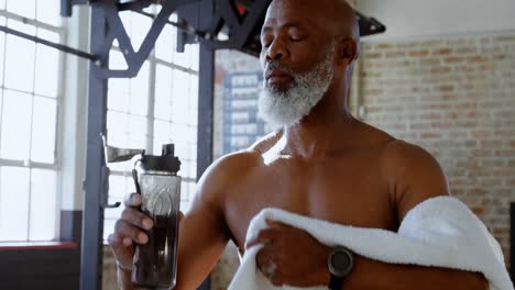 hombre mayor bebiendo agua en el estudio de fitness 4k