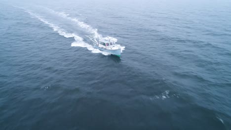 frontal aerial view of a boat speeding across the waters