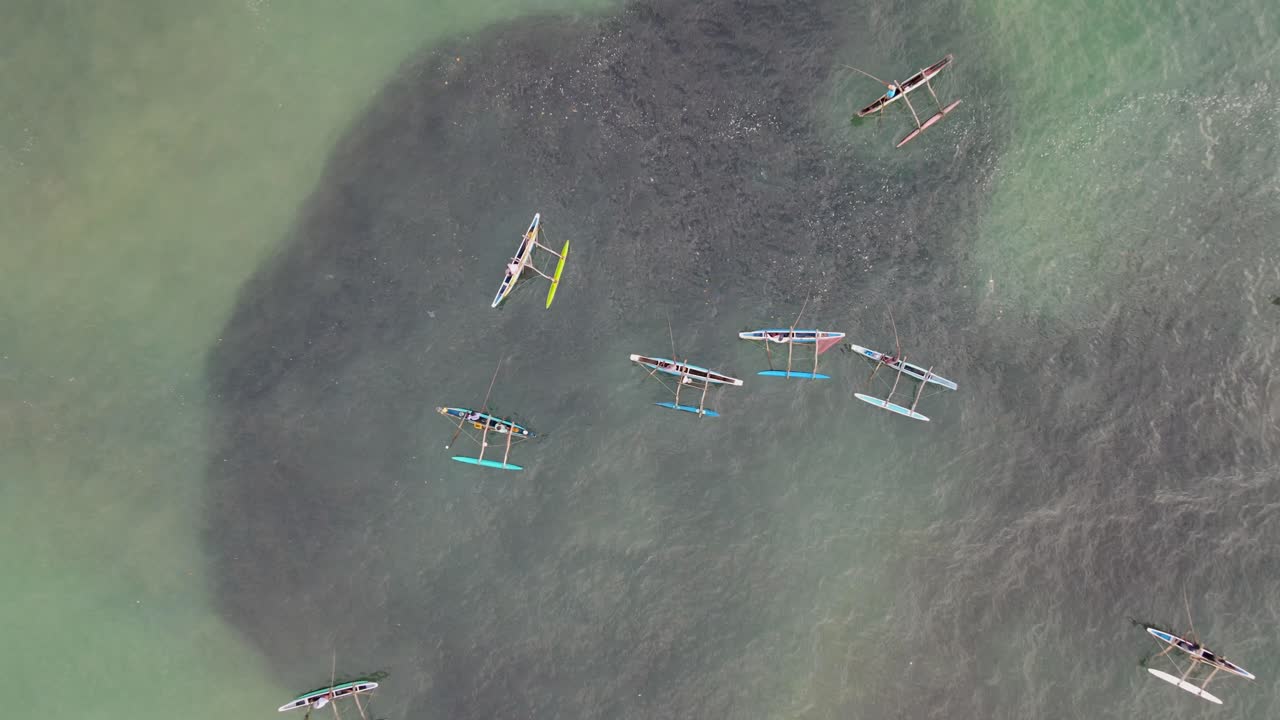 Aerial top down rising over traditional small fishing boats in tropical bay Sri Lanka