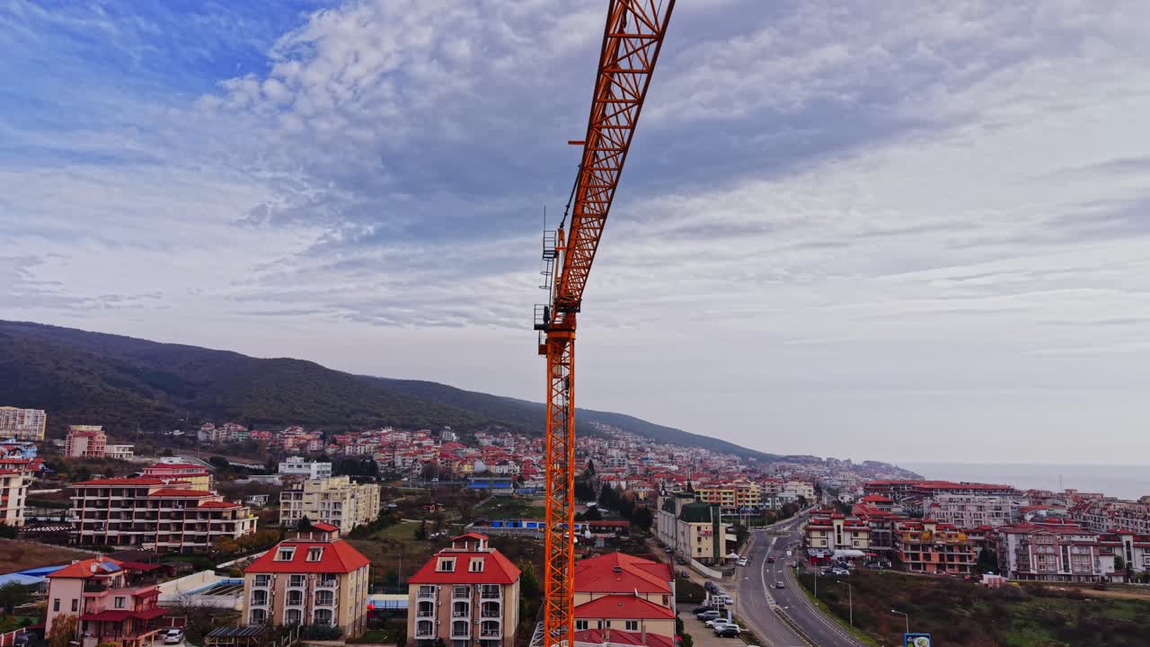Gru edile che domina il panorama sopra una zona residenziale in una città costiera