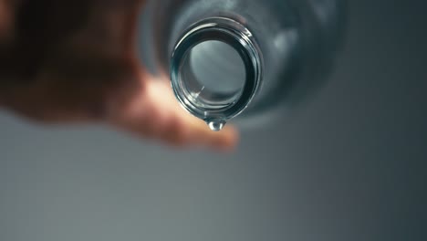 caída de gota de agua de una botella de vidrio vacía, cámara lenta, mostrando la importancia de la hidratación para una vida saludable, alta velocidad, macro