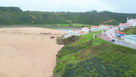 coastal view of the beach near aljezur, portugal, with houses and green hillsides