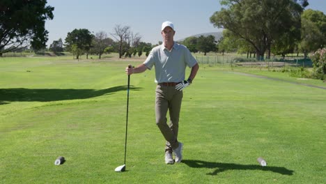 caucasian male golfer smiling at camera on a golf course