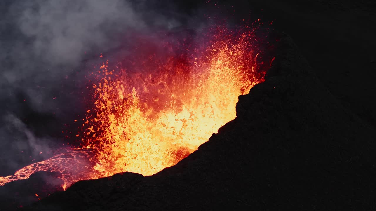 Steady shot of lava bubbling inside the crater, volcano eruption in Iceland - aerial 4k