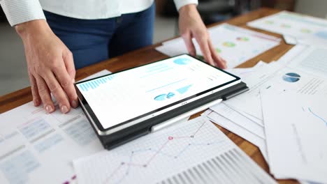 mujer de negocios que utiliza una computadora tablet y gráficos estadísticos lleva a cabo auditoría