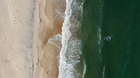 Dolly-in-bird's-eye-aerial-shot-of-the-tropical-Rio-Grande-do-Norte,-Brazil-coastline-with-golden-sand,-turquoise-clear-water-and-waves-crashing-on-shore-in-between-Baia-Formosa-and-Barra-de-Cunha?