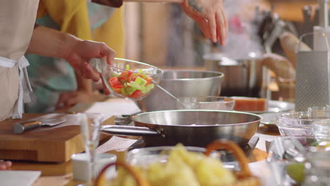 chef frying vegetables in pan during cooking master class