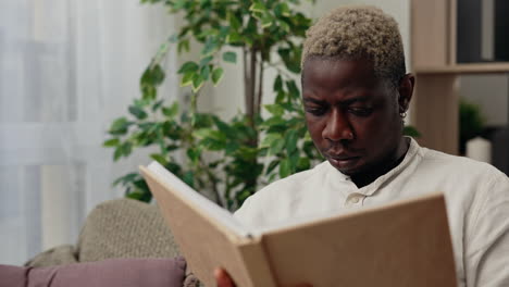 man reading a book at home