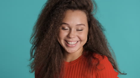 caucasian curly haired woman smiling to the camera.