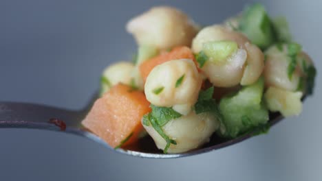 ensalada de chickpea en una cuchara